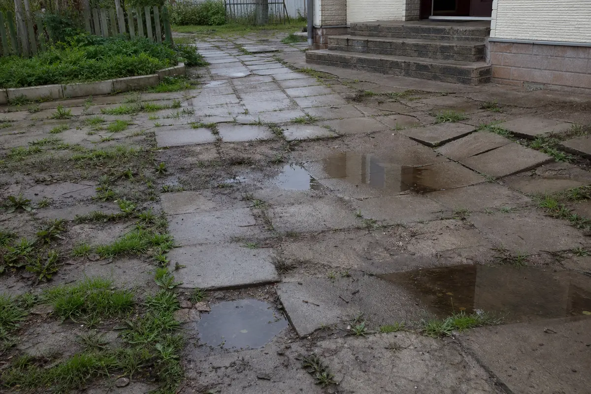 Просевшая плитка, грязные швы и сорняки